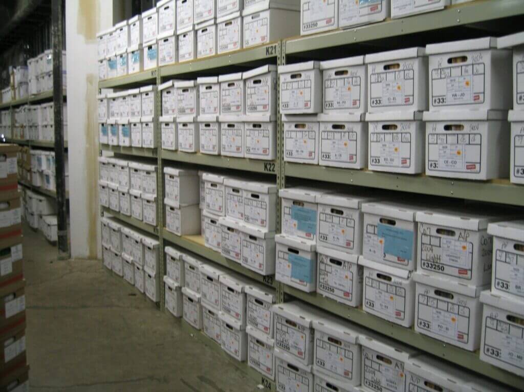 Storage room filled with labeled file boxes.